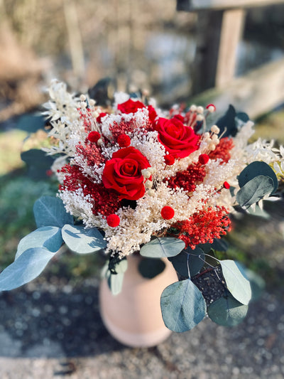 Bouquet Amour orné de roses rouges éternelles, de fleurs séchées blanches et d'eucalyptus. 