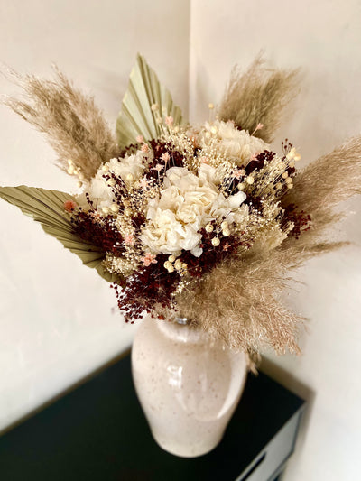 Beau bouquet à base d'hortensias blancs. Il est naturel et sauvage grâce à ses couleurs et les pampas.