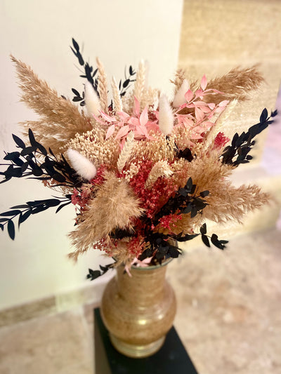 Le joli bouquet Malaya en fleurs séchées. Aux douces couleurs naturelles, il est rehaussé d'un camaïeu de roses.